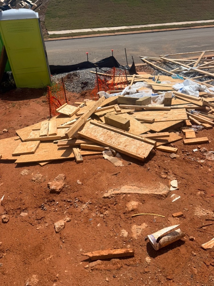 Pile of scrap lumber and construction debris on a job site before removal